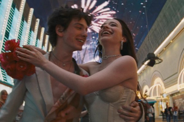 Кадр из фильма «Анора»: пара смеётся на фоне неоновых вывесок
